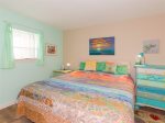 The bedroom has a king sized bed with coastal decor 